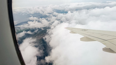 Views from an airplane window of clouds under the wing.