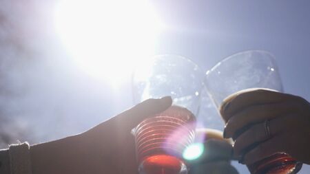To clink glasses of beautiful glass with beer and other alcohol on the background of the sky and the...