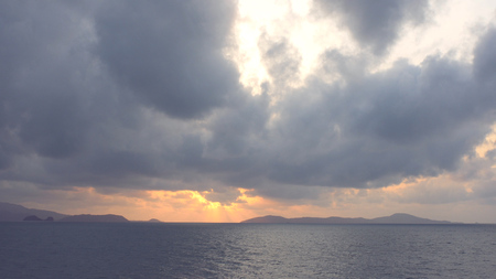 Beautiful dawn in the clouds above the hills and the sea. HDの写真素材