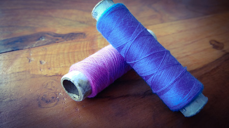 colorful sewing threads on wood background