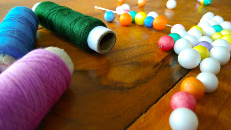 colorful sewing threads with colorful bubbles on wood background