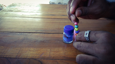 Color paints with sewing threads and color bubbles on wood backgroundの写真素材