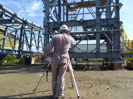 A land surveyor engineer during his work with surveying using theodolite or total station...