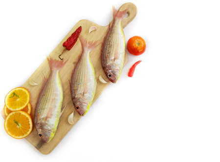Fresh Pink Perch fish with ingredients like lemon,curry leaves,chilli,selective focus.white background.space for text.の写真素材