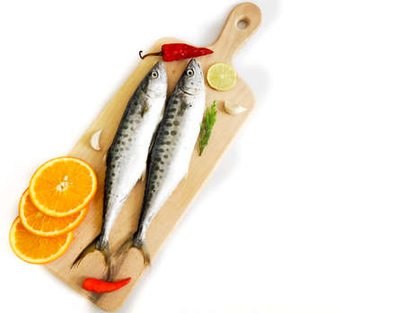Fresh Seer Fish,King Fish decorated with herbs and vegetables on a wooden pad,Selective Focus.
