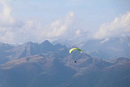 mountainscape with a hang glider and a mountain range in the distanceの写真素材
