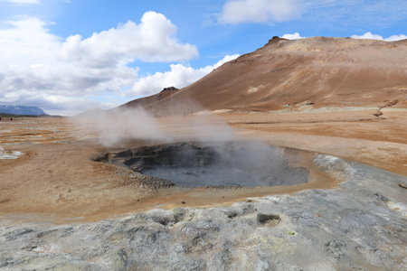 dark gray mud boiling and fuming in a geothermal mud pot in Namaskard geothermal area in Iceland