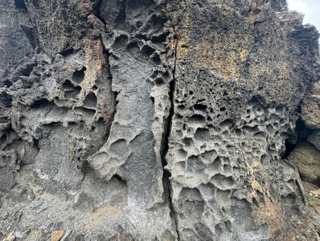 close up of a molten lava rock formation showing the porous holes in the brittle stoneの写真素材