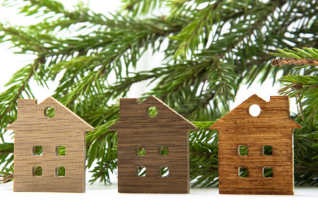 A small figure of a wooden house on a background of green fir branchesの写真素材