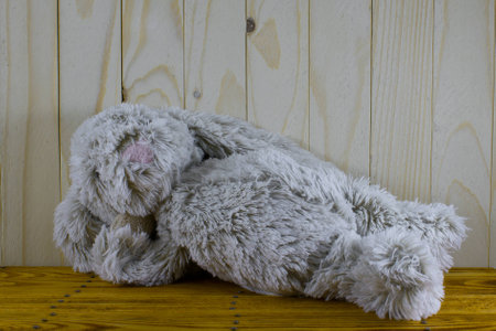 plush Bunny lying on a wooden table and wood backgroundの写真素材