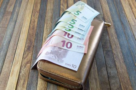 women's money purse with gold color on wooden background
