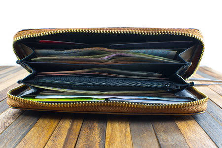open wallet with money and credit cards on wooden background