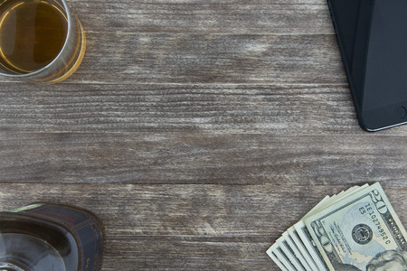 20 us dollar banknote, glass of whiskey and bottle on wood backgroundの写真素材