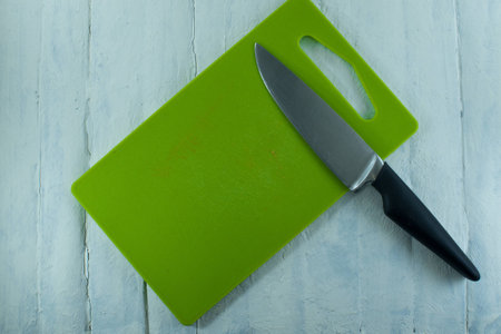 cutting Board and large knife on white tableの写真素材
