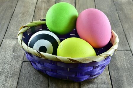 Easter eggs in a basket on wooden background