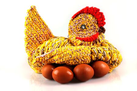 Amateur knitted hen on eggs  isolated on the white background の写真素材
