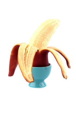 Red banana in a dark blue support for eggs isolated on the white backgroundの写真素材
