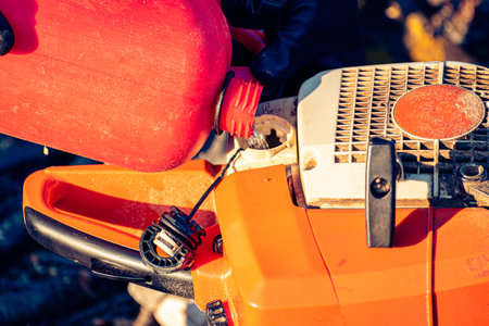 Refilling the tank of a chainsawの写真素材