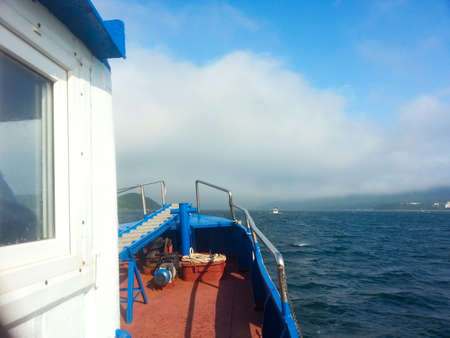 Fishing boat on the sea in the fog. View from the side.の写真素材