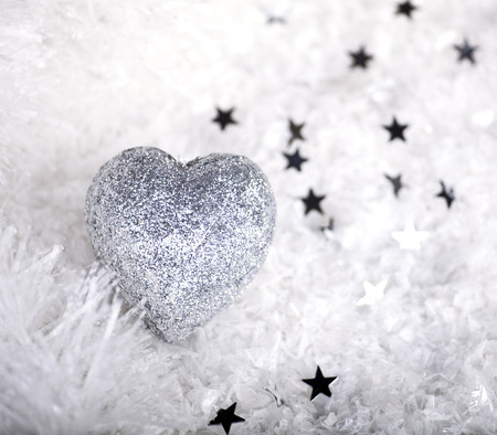 Silver Christmas heart on a snow background.の写真素材