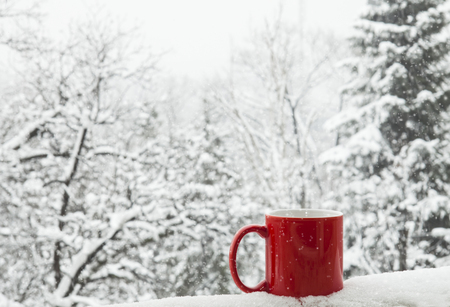 Red cup of coffee on a beautiful snow winter background.の写真素材