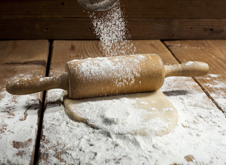 Flour and dough with kitchen utensils on wooden background.の写真素材