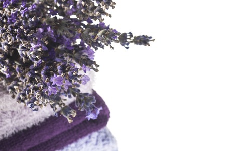 Spa background with bunch of lavender and towels on a white background with copy space.の写真素材