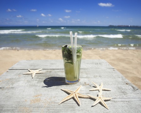 Glass of fresh mojito cocktail on the beachの写真素材