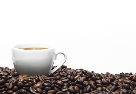 White coffee cup and coffee beans isolated on a white background.