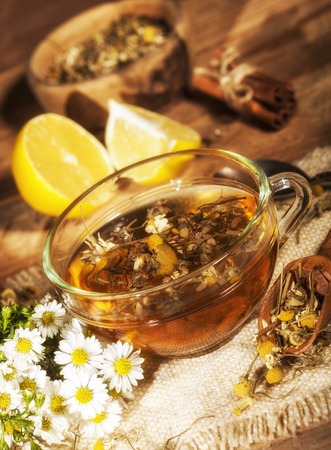 Cup of chamomile tea with chamomile flowers on wooden planksの写真素材