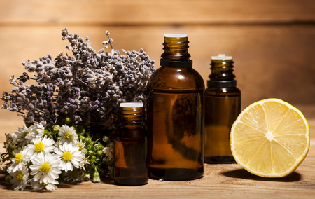 Chamomile, lemon and lavender essential oil on wooden backgroundの写真素材