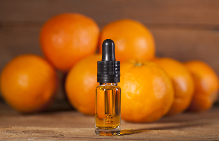 Bottle of essential oil from oranges on wooden background - alternative medicineの写真素材