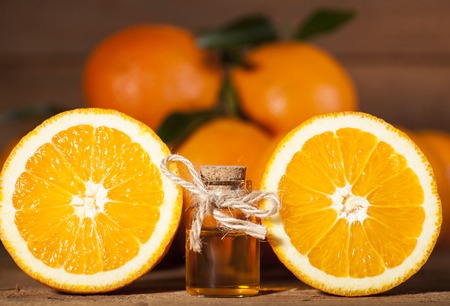 Bottle of essential oil from oranges on wooden background - alternative medicineの写真素材