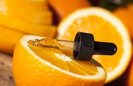 Bottle of essential oil from oranges on wooden background - alternative medicineの写真素材