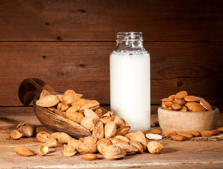 Almond milk with almond on a wooden tableの写真素材