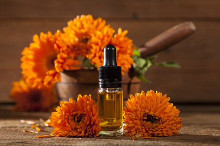 Essential oil made from marigold on rustic wooden backgroundの写真素材
