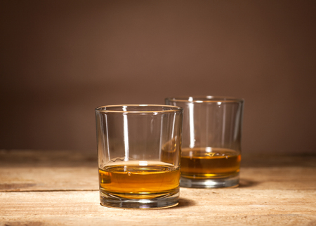 Glasses of scotch on wooden vintage background