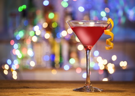 Glass of cosmopolitan cocktail on a bar lights background.の写真素材