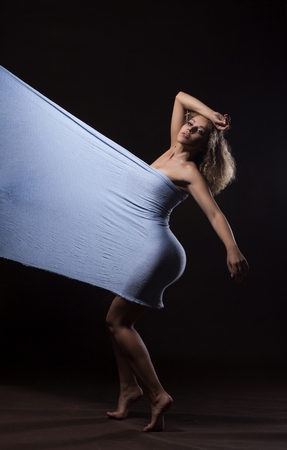 Beautiful young girl dancing with blue fabricの写真素材