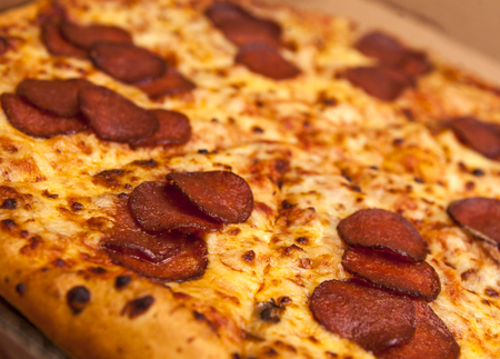 Hot Sliced Pepperoni Pizza In Delivery Box On Wooden Backgroundの写真素材