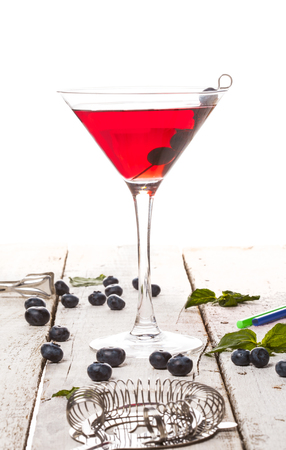 Summer cold drink with blueberry, mint and ice in glass on white wooden backgroundの写真素材