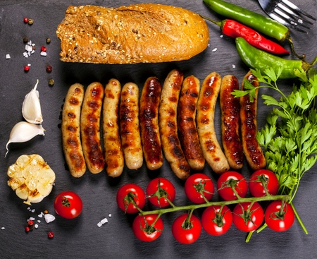 Wiener Sausages with vegetables on black background. Top view.の写真素材