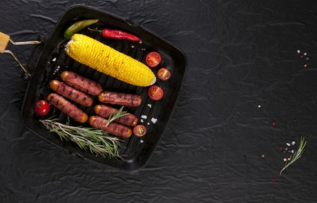 Festive cocktail sausages wrapped in crispy smoked bacon commonly known as 'Pigs in Blankets' on a black backgroundの写真素材