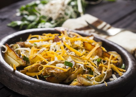 Baked potato wedges with cheese, chives and dill. Homemade organic vegetable vegan vegetarian potato...