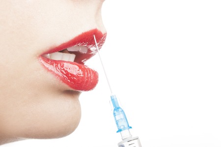 Beautiful young woman receiving filler injection in lips, closeup on white background with copy space for textの写真素材