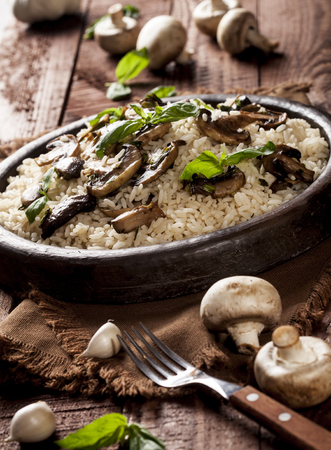 Cooked white rice with mushrooms in a bowl on wooden background.の写真素材