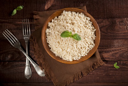 Cooked white rice in a bowl on wooden background. Top view with copy space.の写真素材
