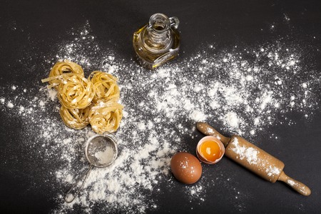 Italian traditional raw pasta on the black stone background. Top view with copy spaceの写真素材