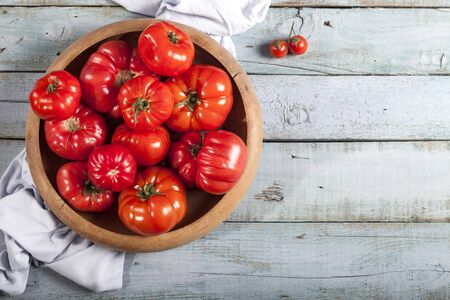 Tomatoes on rustic blue wooden background top view copy space.の写真素材