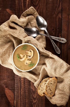 Delicious creamy mushroom soup with dill and close-up on the dark wooden background.の写真素材